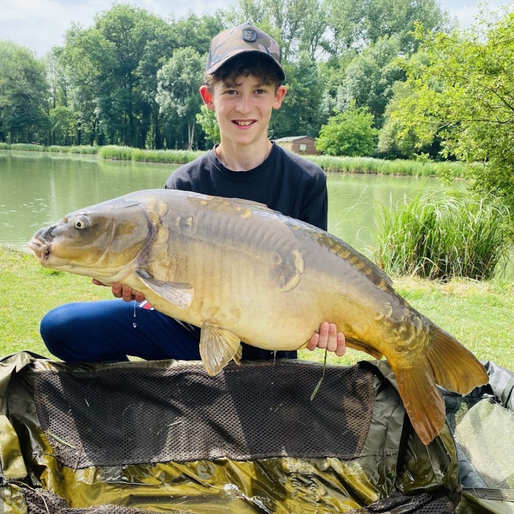 Très belle carpe miroir pêchée au domaine de la brame par un jeune pêcheur