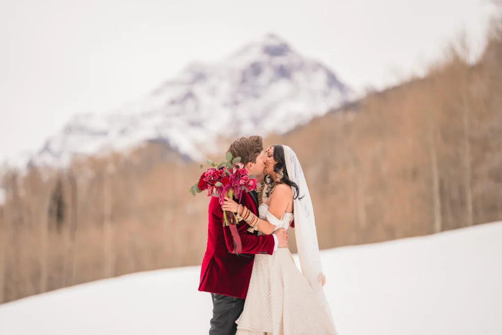 Couple embracing with mountain views during T-Lazy 7 elopement Aspen winter