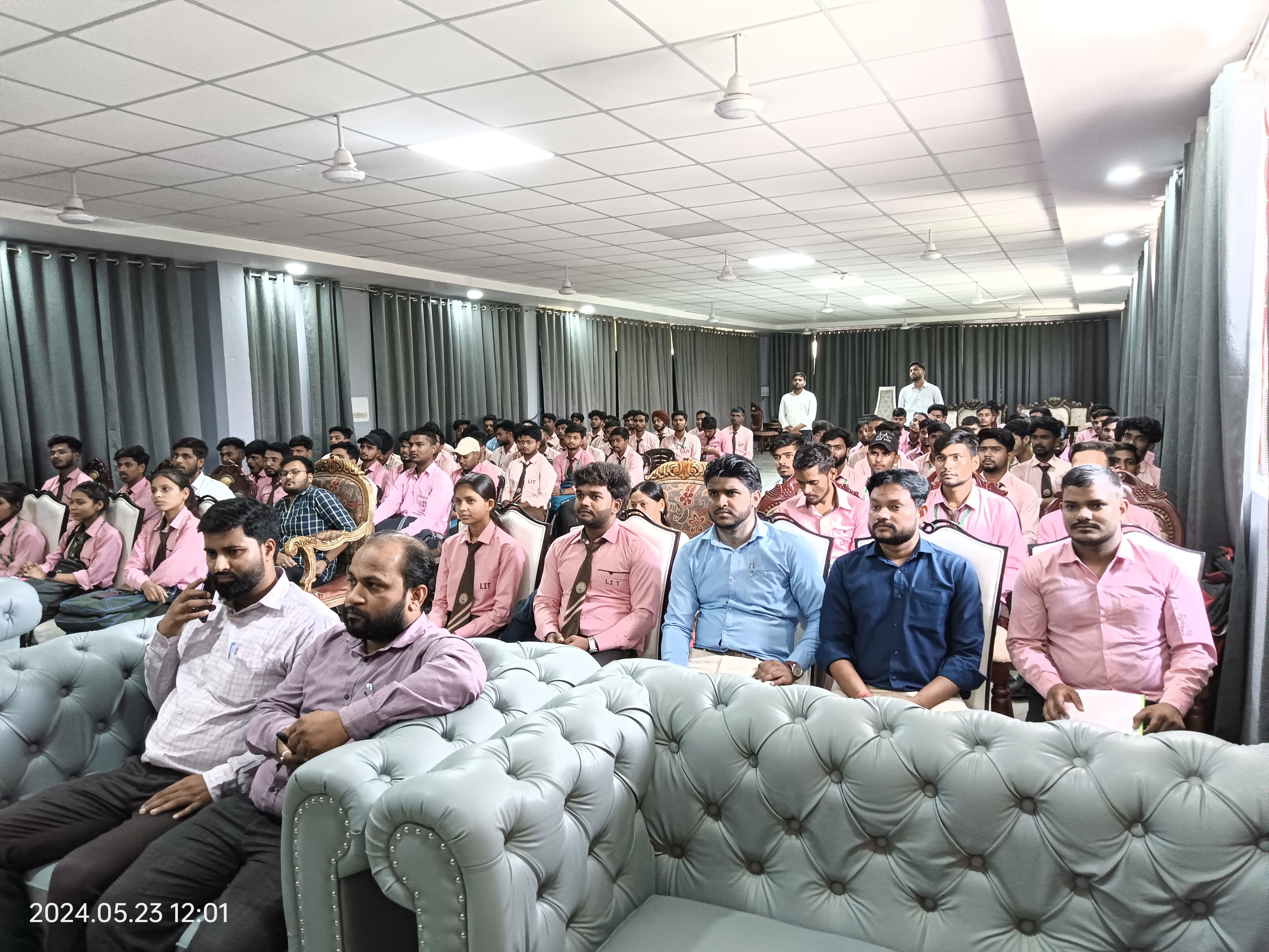 man standing in front of people sitting beside table with laptop computers