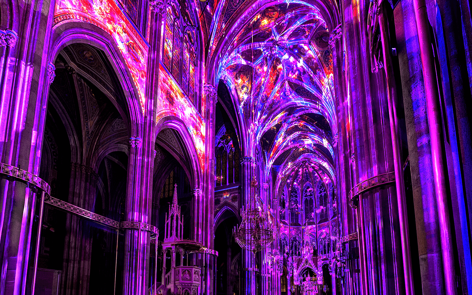 Vibrant light display inside Votivkirche, Vienna, showcasing colorful illuminated arches.