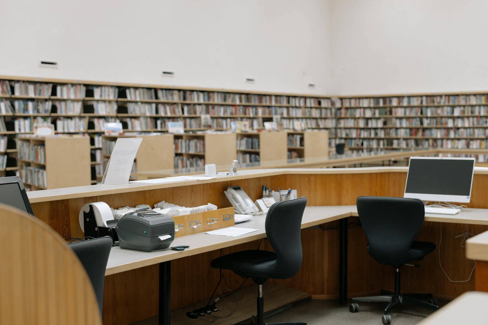 An overhead shot of a wooden desk covered in open textbooks, colorful sticky notes, and highlighted research papers.