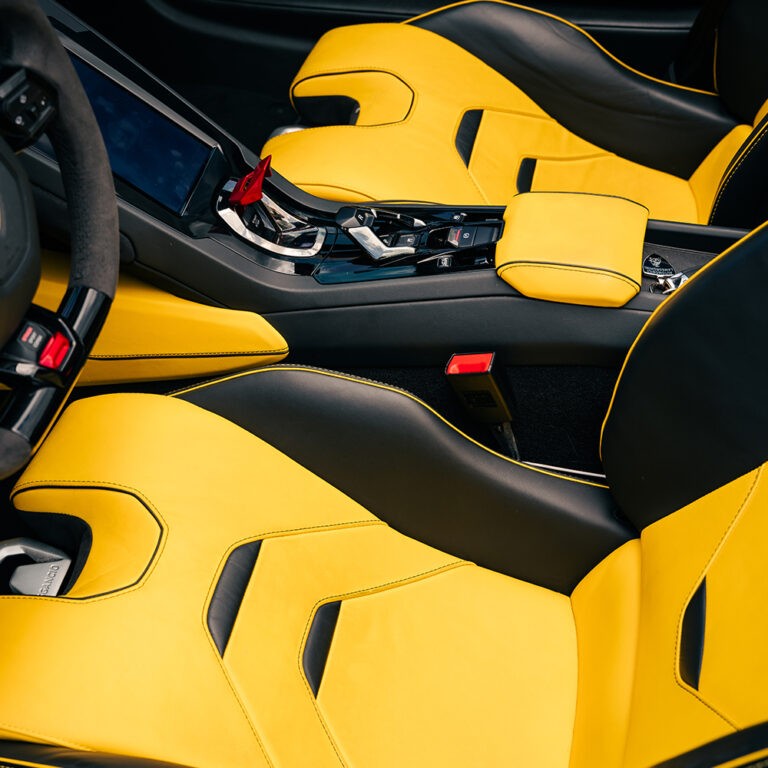 Close-up of yellow and black interior accents in Lamborghini Huracán EVO Spyder, premium materials.