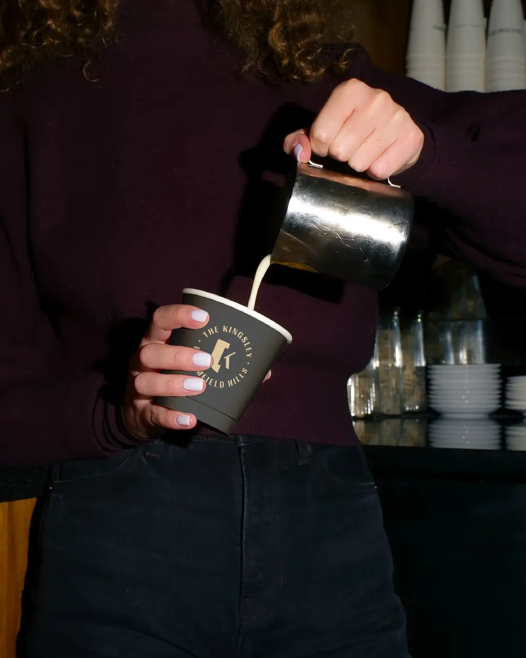 Pouring coffee into a branded cup