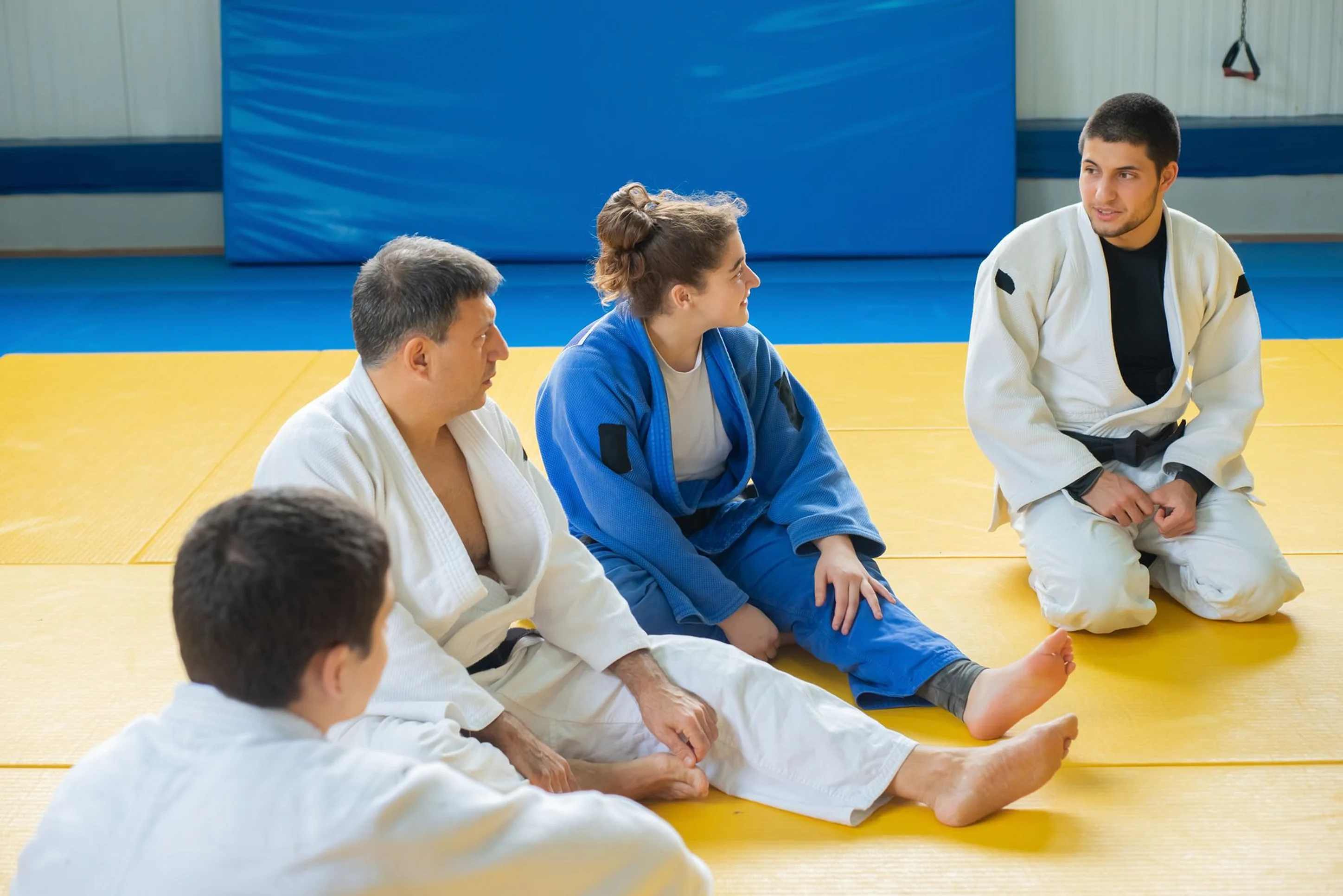 Martial arts students sitting together on the training mat during a class at Rai Martial Arts.