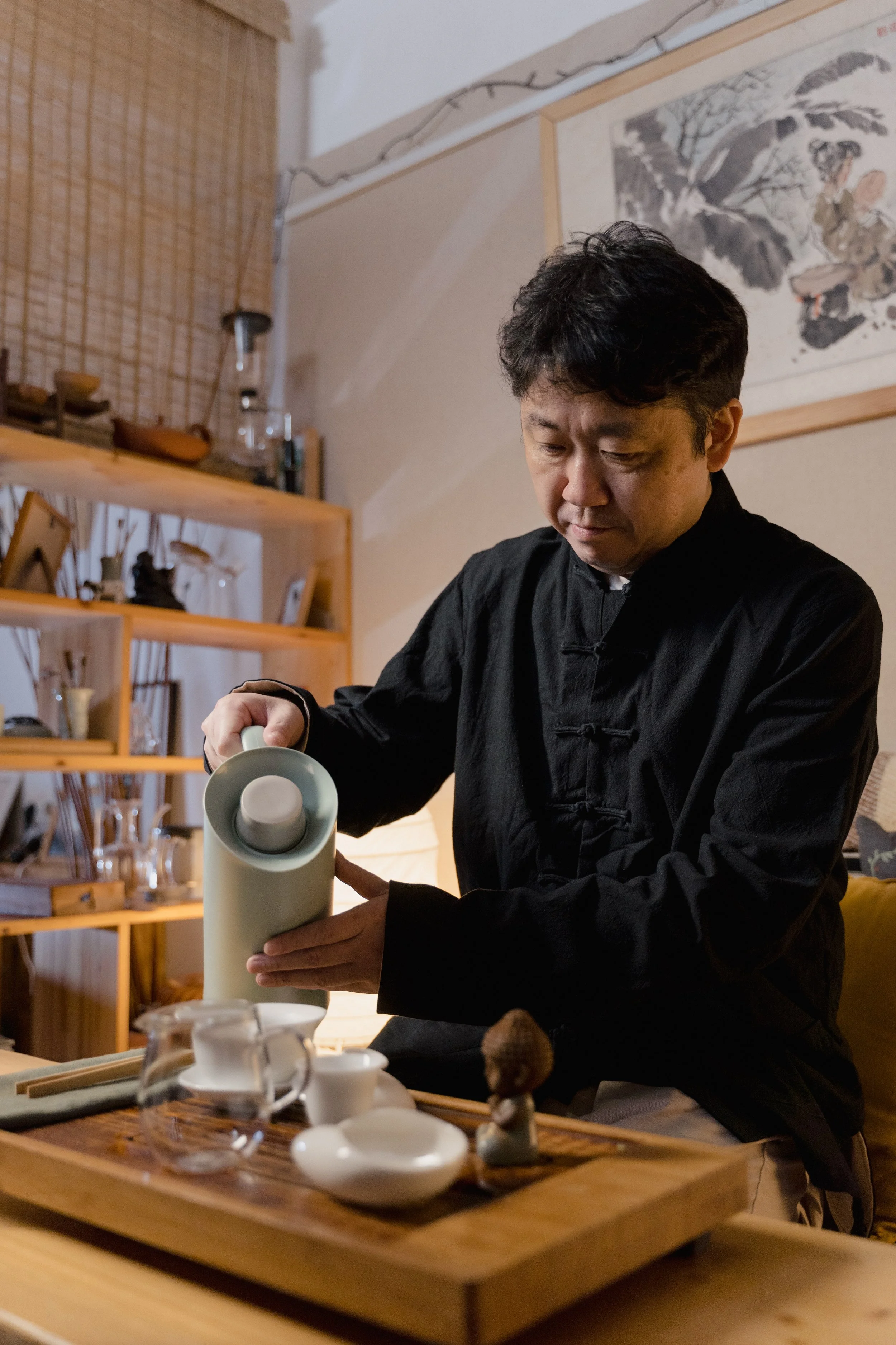 A man practices self-care by pouring himself a relaxing cup of tea