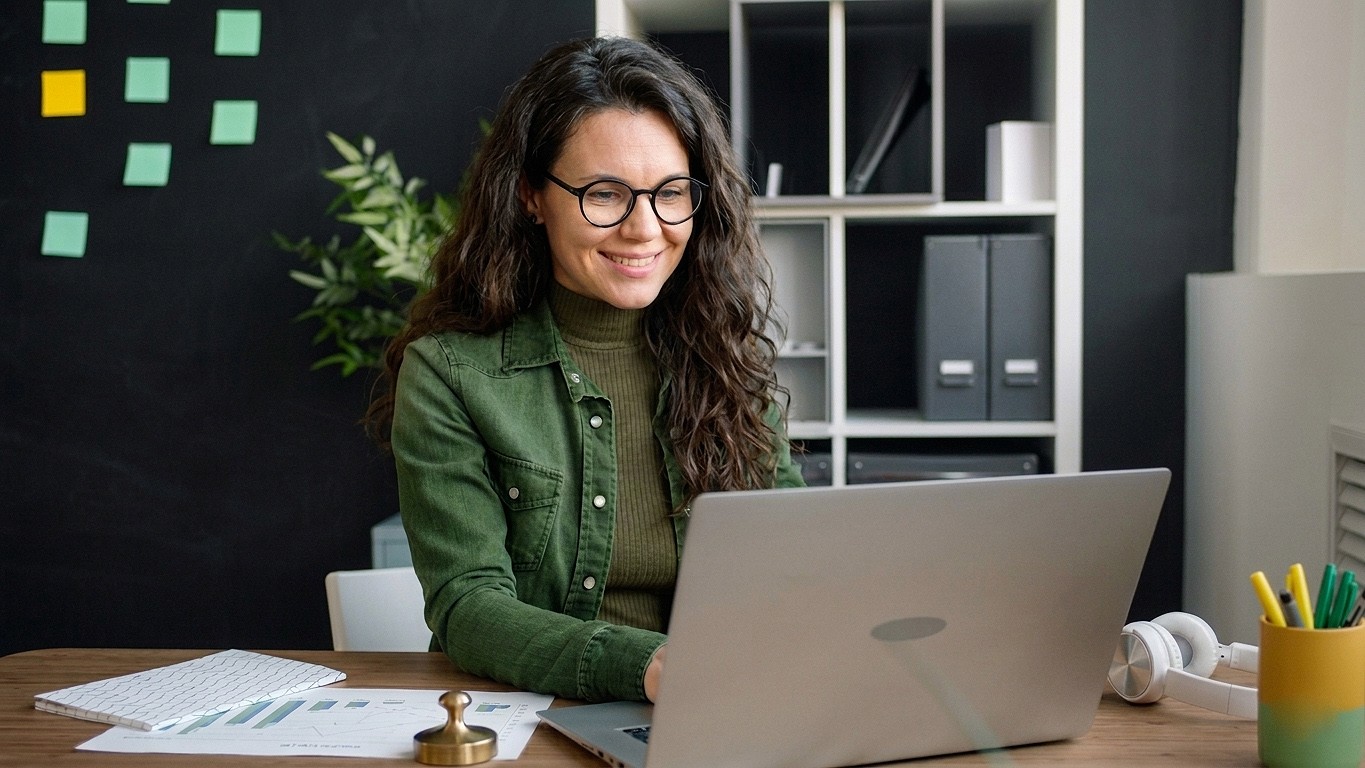 Confident woman at her workspace, looks at her computer to read about markdown format benefits