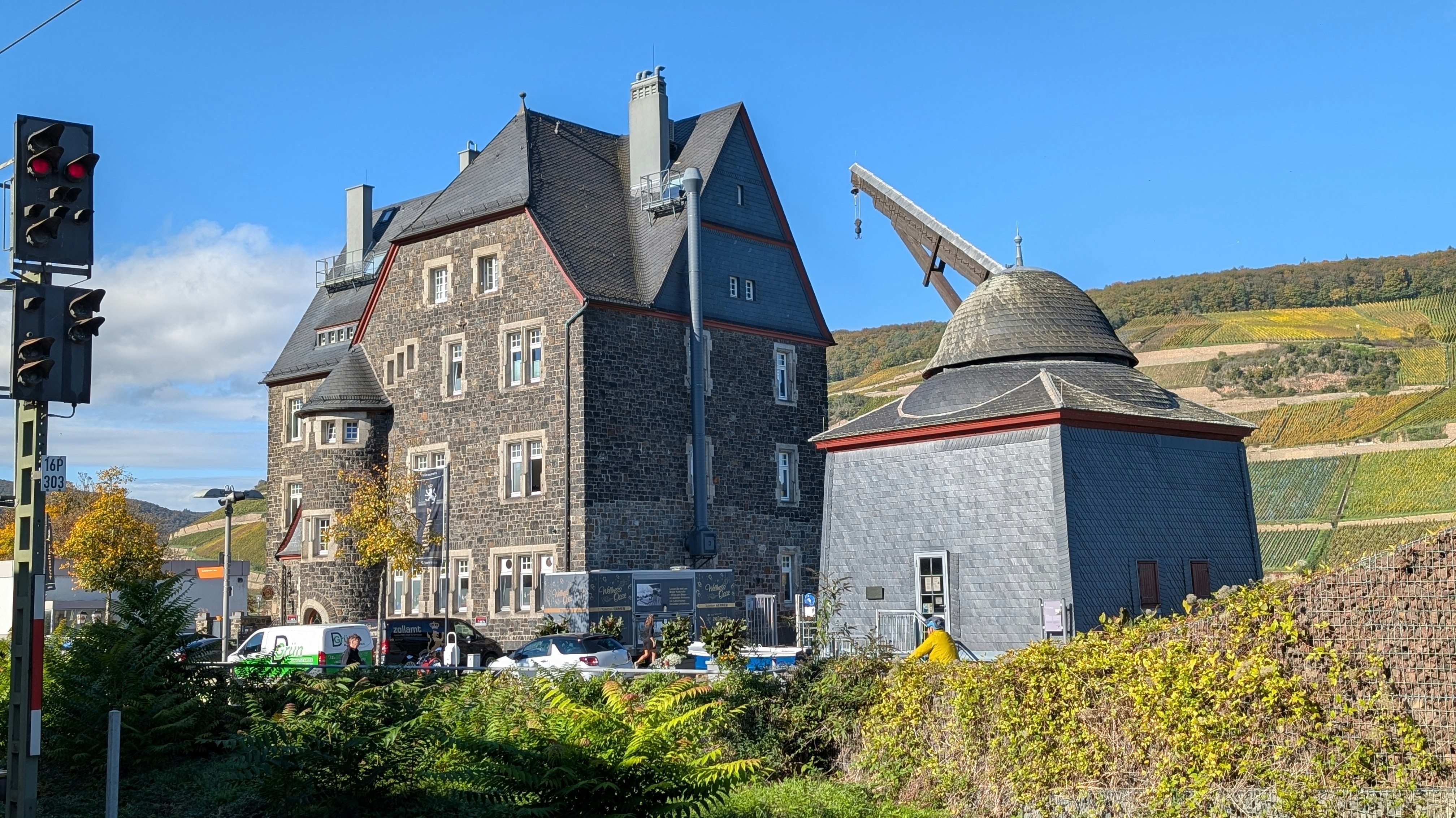 A stone building stands near a unique wooden structure.