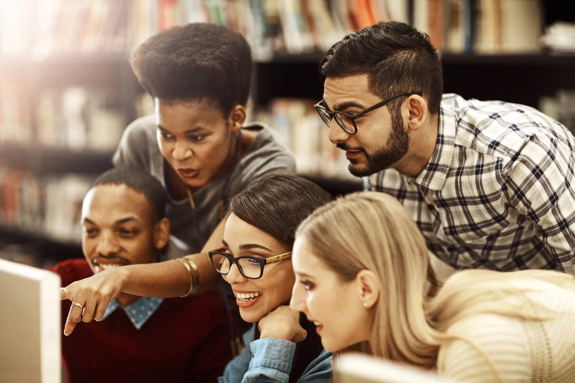 a group of young adults looking at a computer