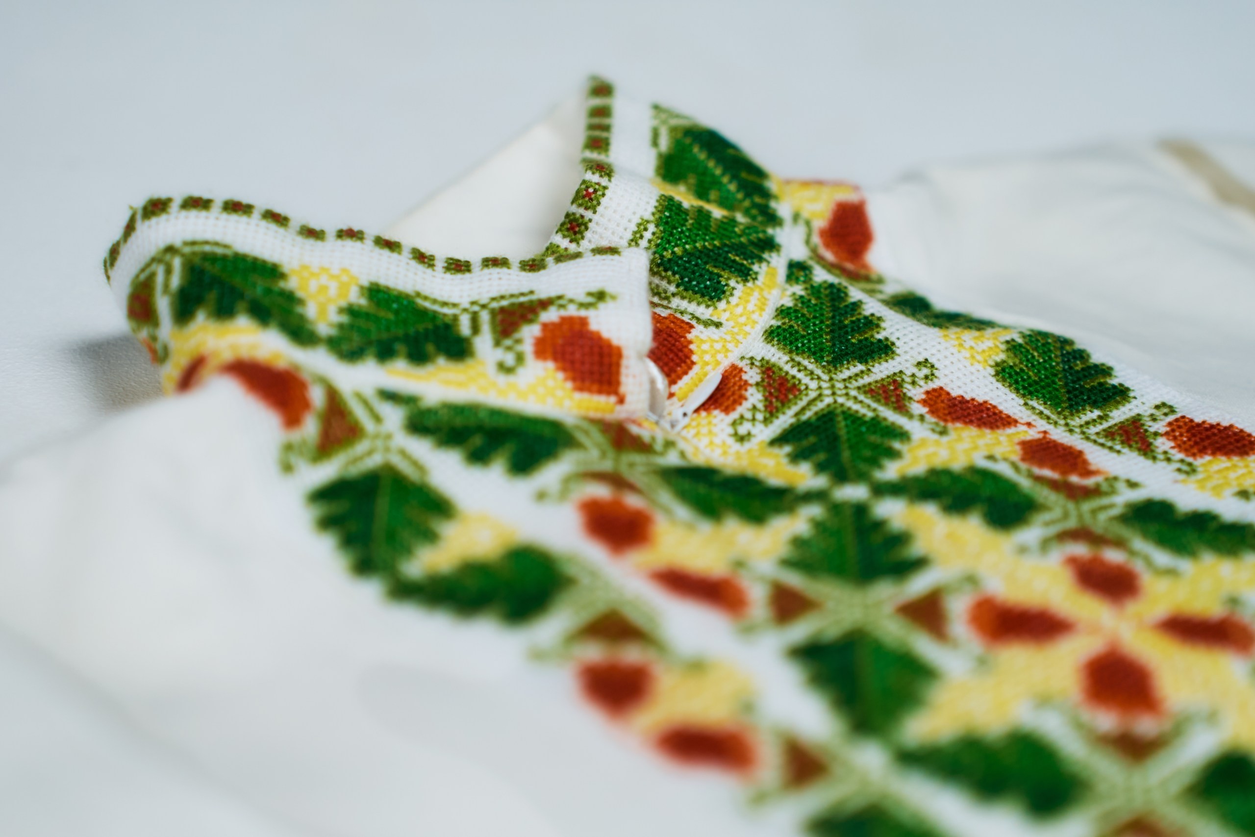 A hand-embroidered green shirt with geometric cross-stitch patterns, crafted by the person.