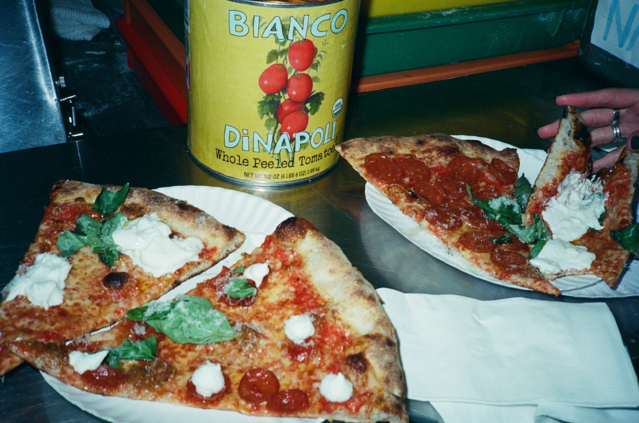 Pizza slices and fresh tomatoes at a food market
