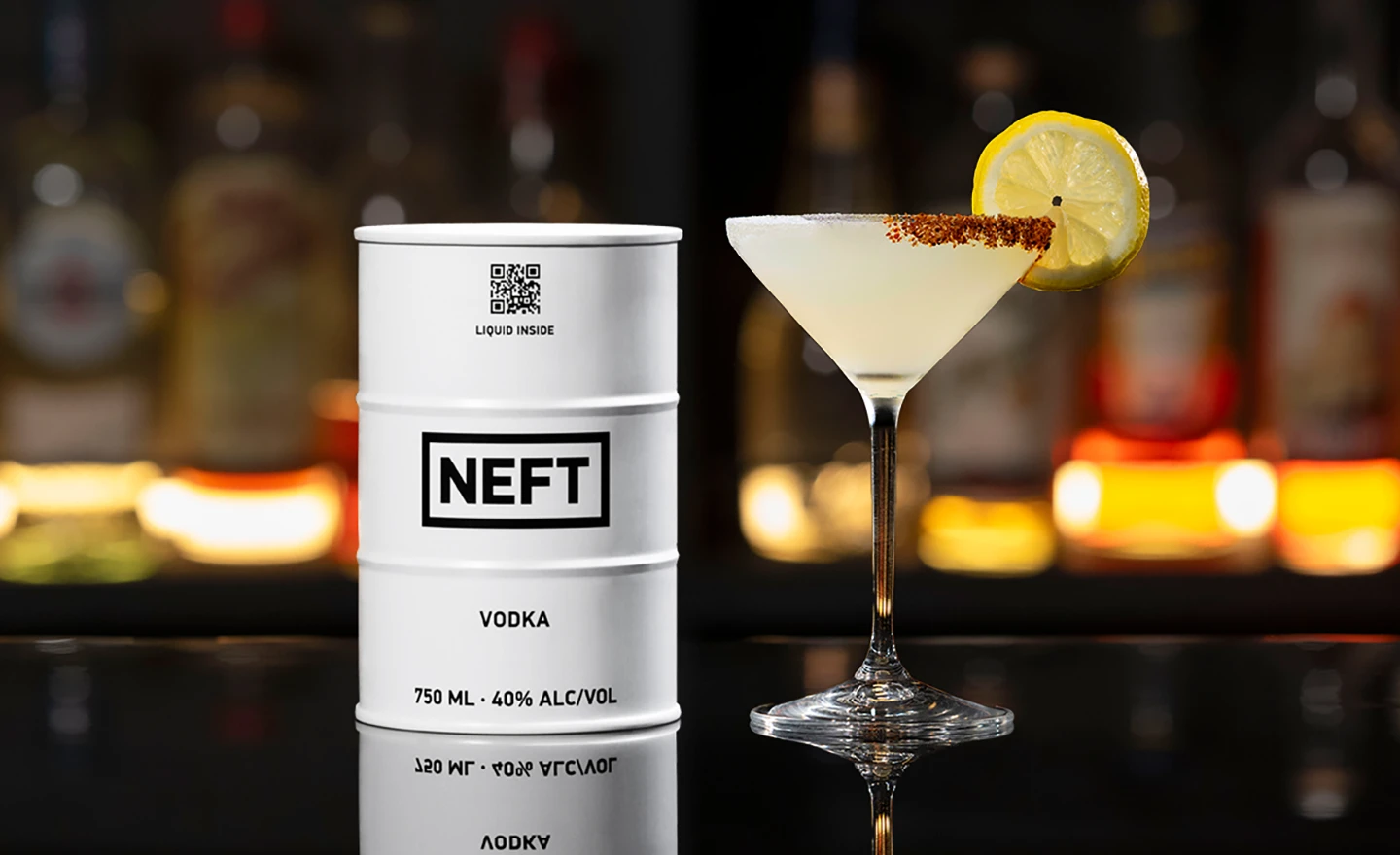 A NEFT Vodka Barrel and a glass of Lemon Drop on a bar counter.