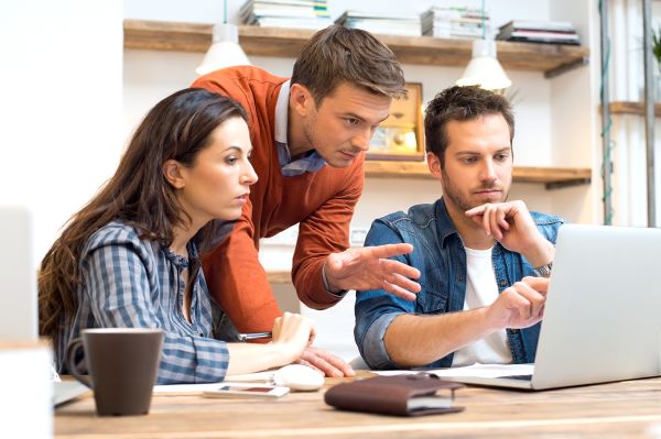 group of people working together over laptop