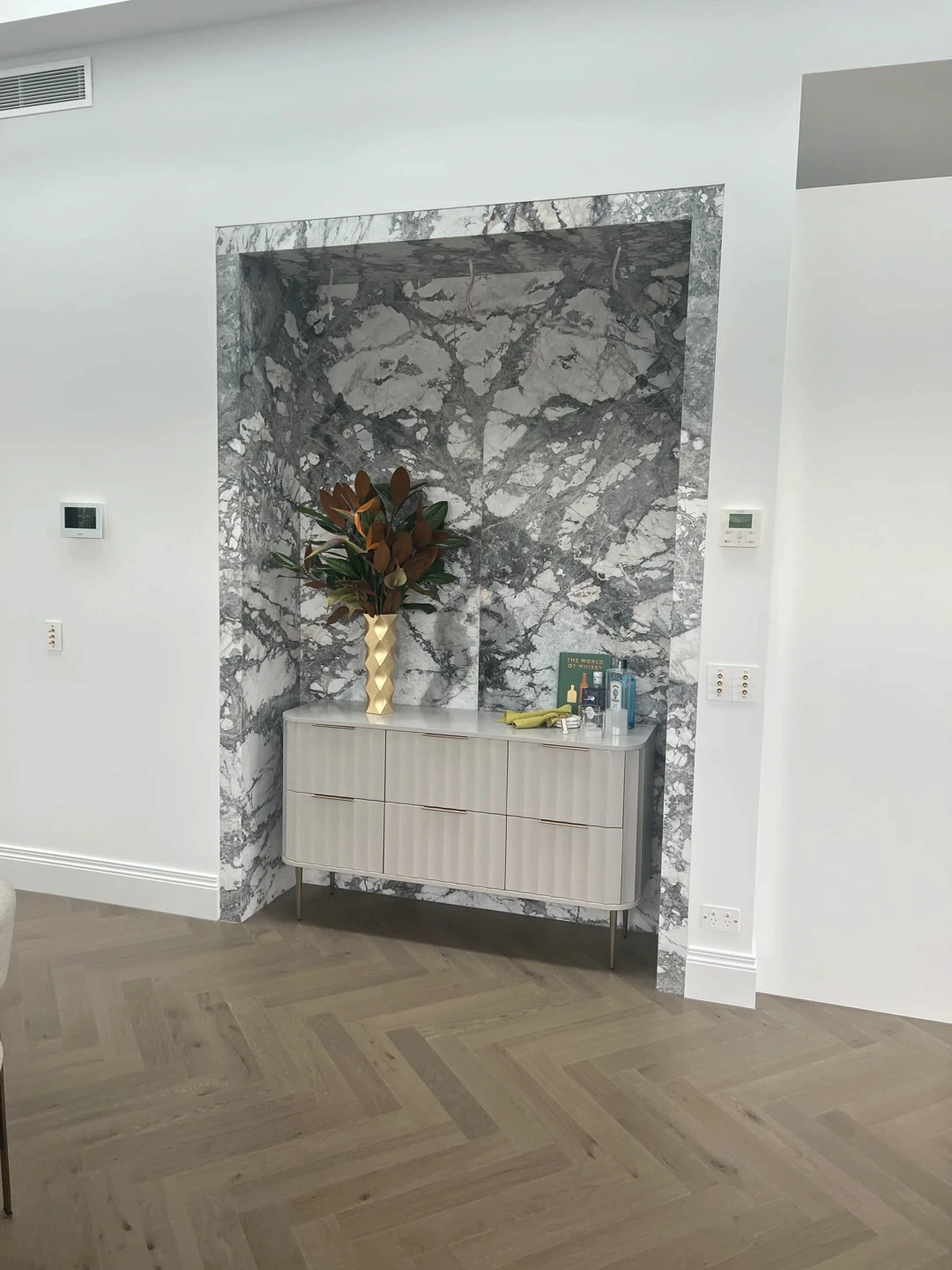Bookmatched marble wall cladding with dramatic natural stone veining, precision-fitted panels, and a polished feature wall finish for a refined interior installation.