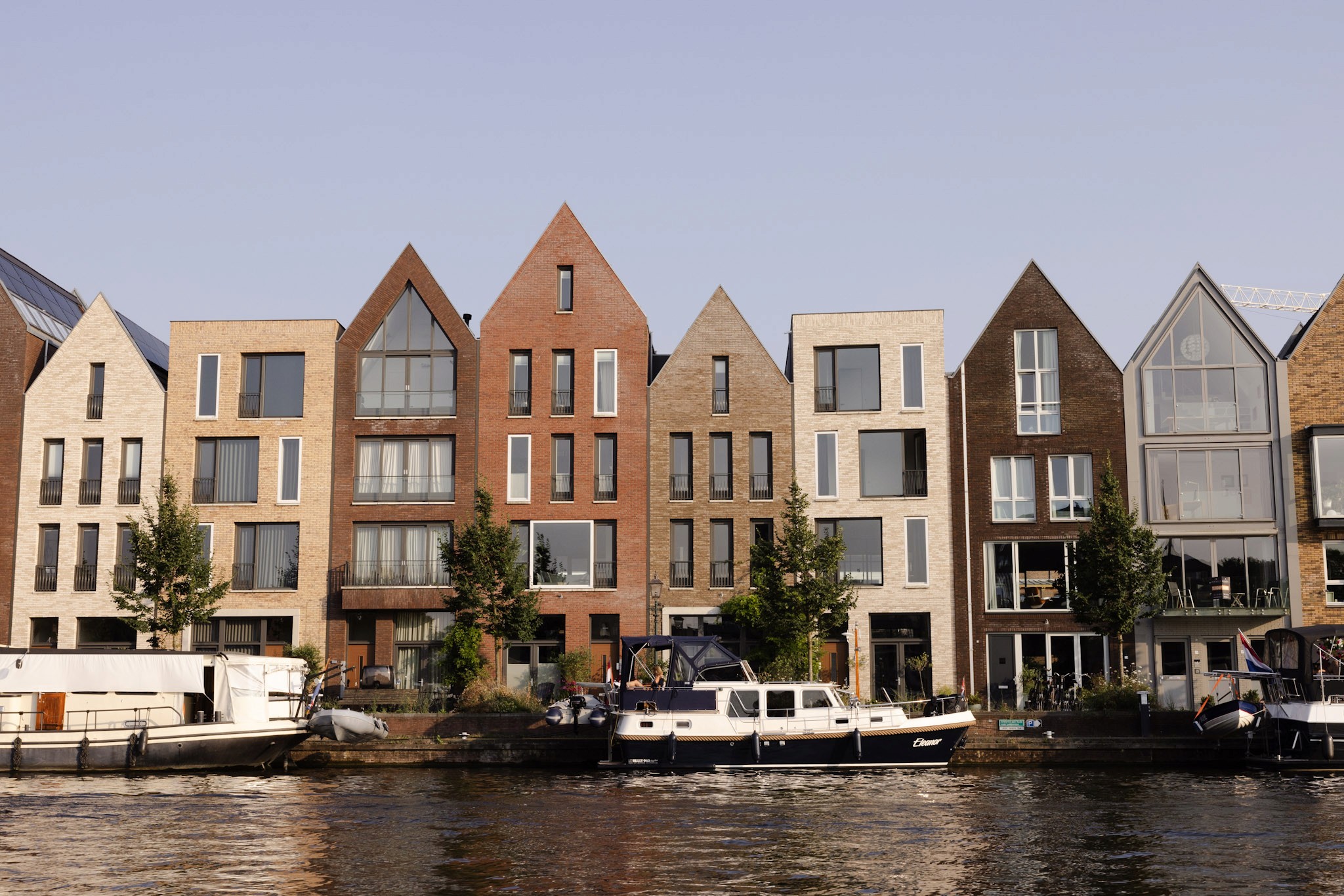 Fotografie van een rij charmante historische huizen in Haarlem, vastgelegd in warme middagzon die de architecturale details benadrukt