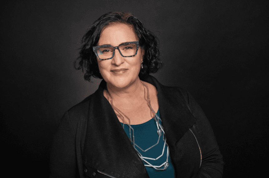 Portrait of Natasha Goldman against a neutral background with accompanying announcement text.