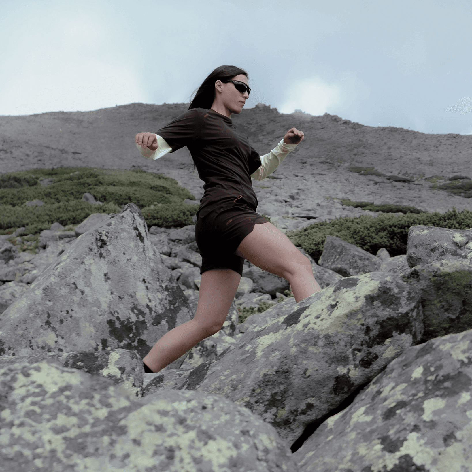 picture of woman running in the rocky landscape.