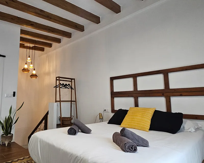 Geräumiges Schlafzimmer mit Holzbalkendecke und natürlicher Einrichtung im La Terraza Tarifa