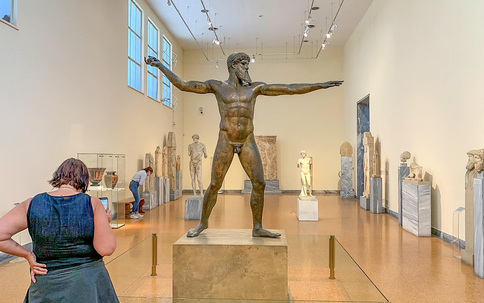 游客正在国家考古博物馆内欣赏古代雕塑。