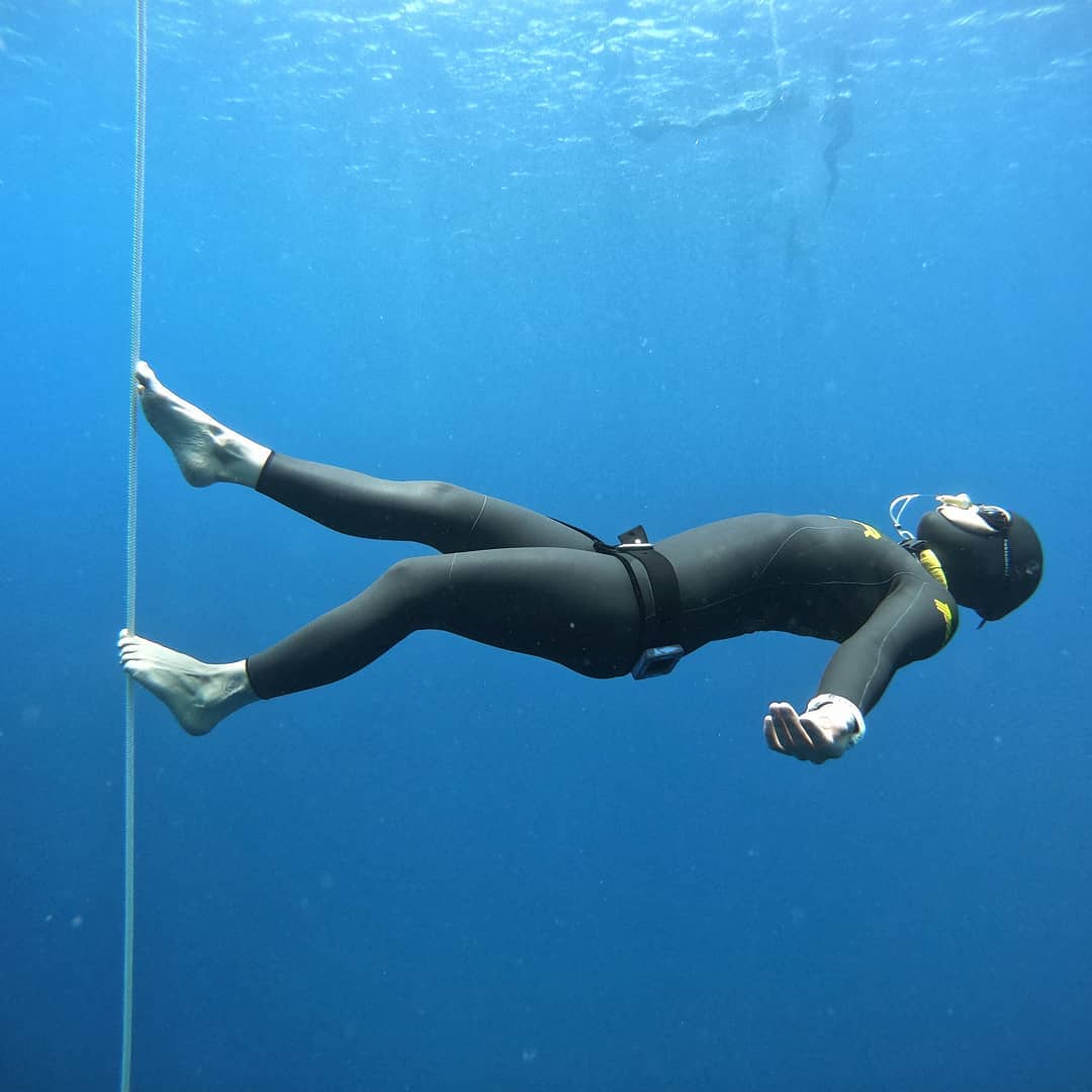 freediver meister athlete walking on a string underwater