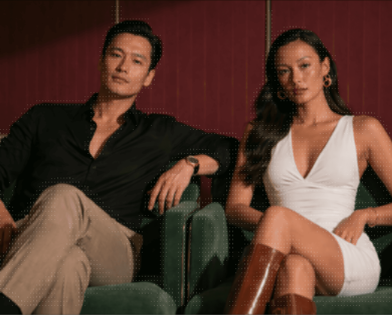  A man and woman sitting together on green chairs in a casual setting.