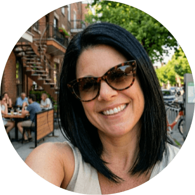 A person on a white shirt and black coat standing at the window indoor of the office