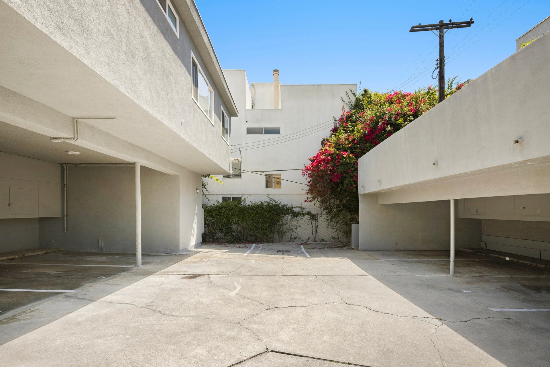 Covered parking area with open carport layout and concrete courtyard at 11921 Goshen Ave.