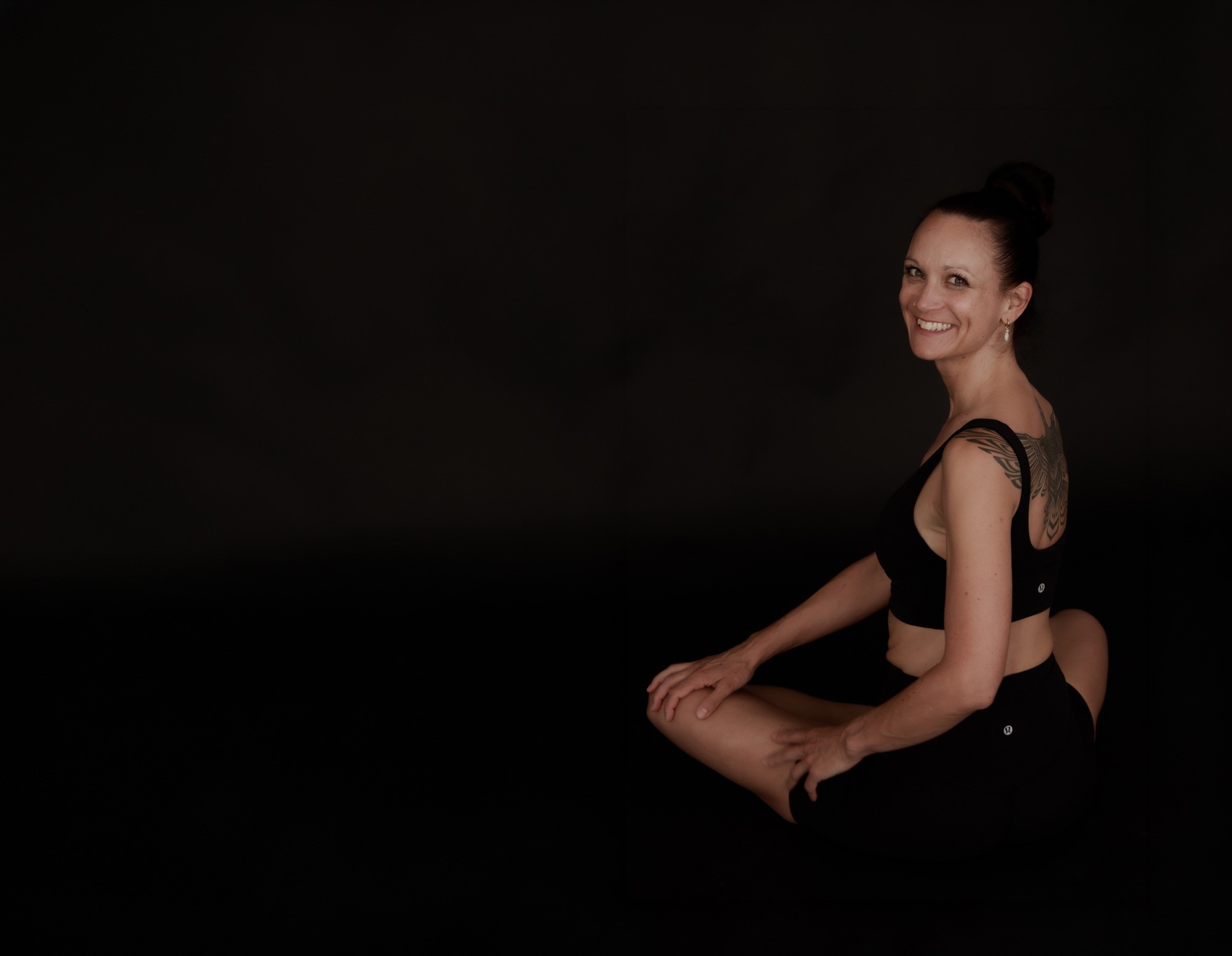 Annika in einer ruhigen Yoga-Pose in dunkler Umgebung