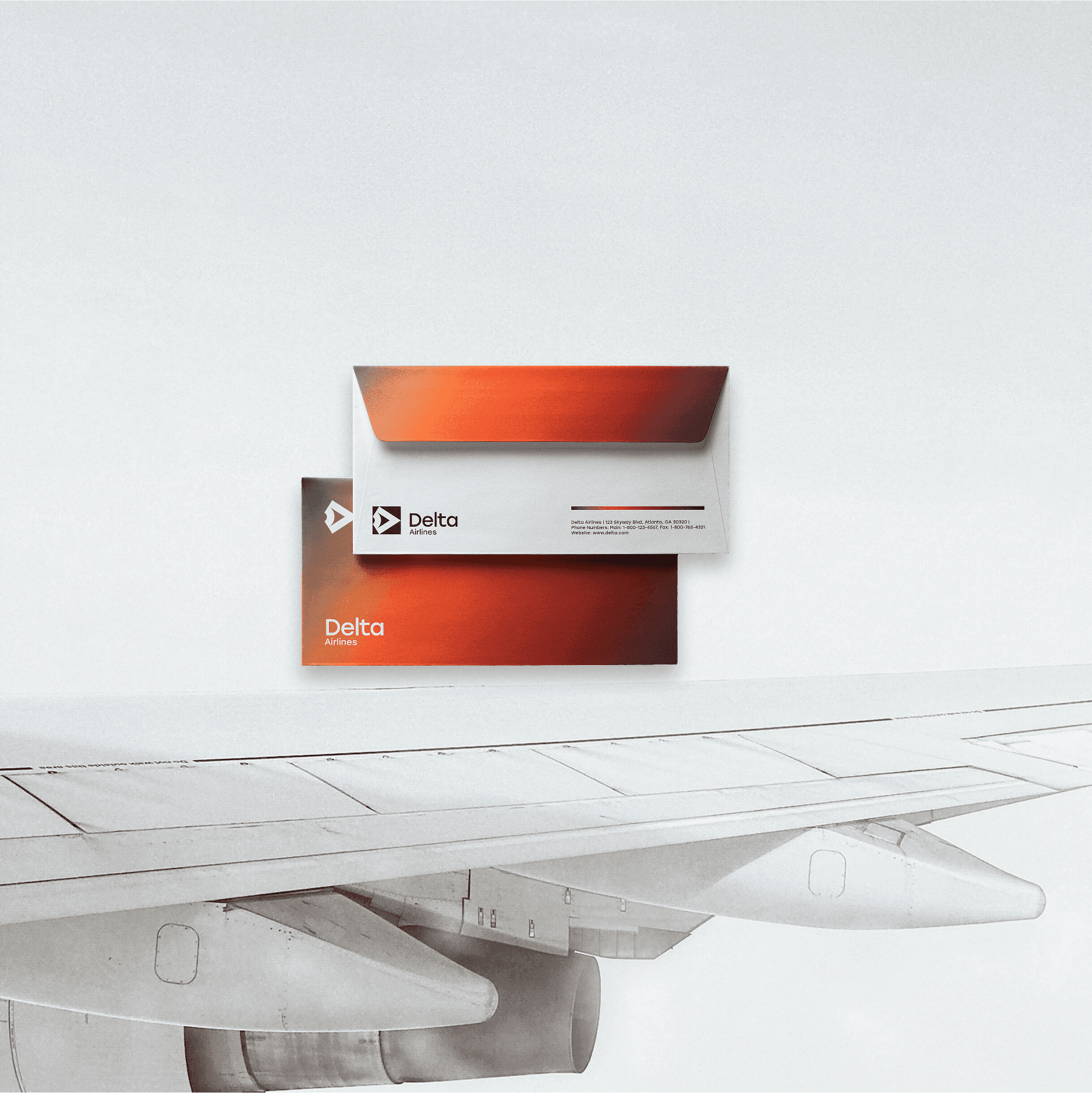 The image features a set of sleek, modern Delta Airlines stationery, including an envelope and paper with a red and silver design, displayed in front of an airplane wing.