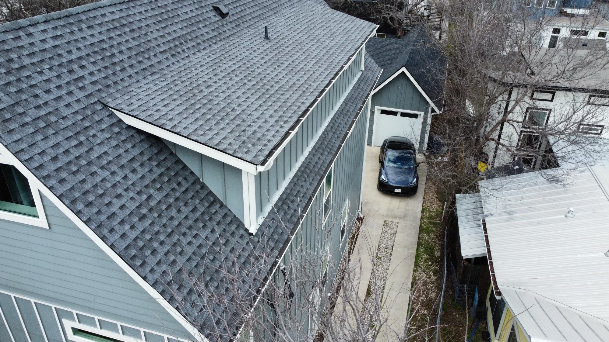 Pewter grey architectural shingle roof on a two-story house with clean lines and a professional finish by Barnes N' Roofs.