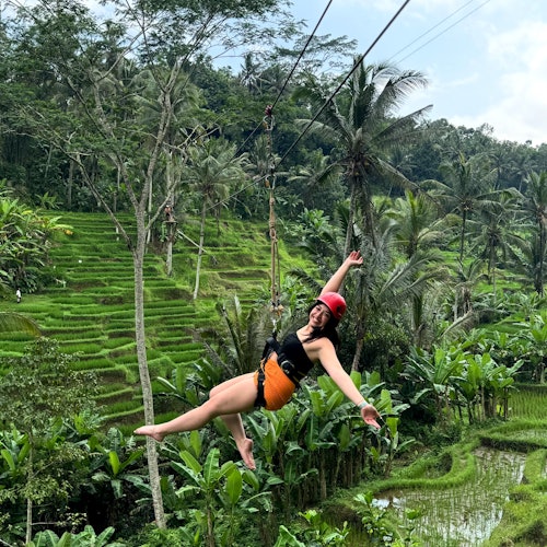 Uファンフィールドパークの美しい緑の稲田を楽しげにジップラインで滑走する女性