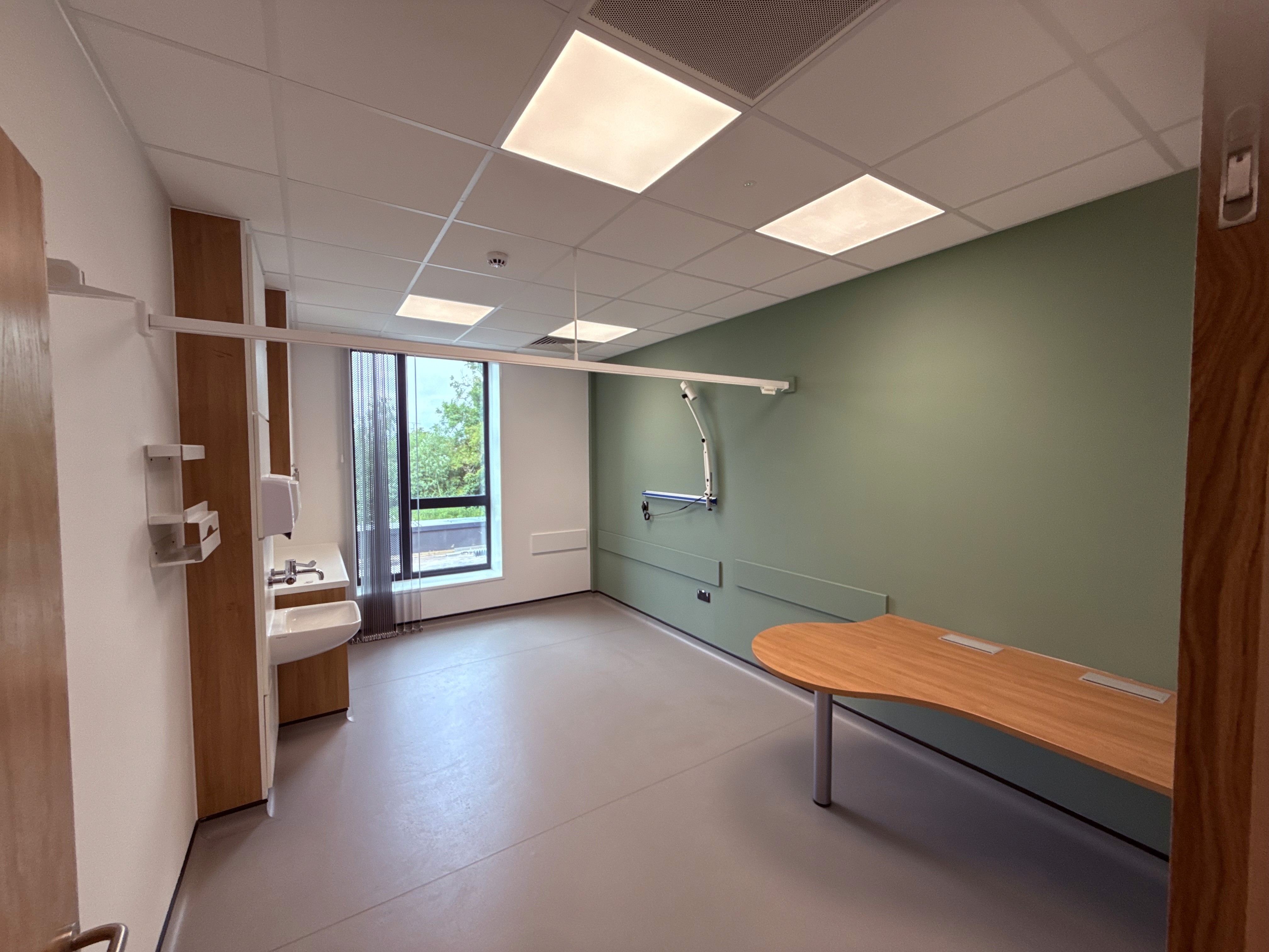 Treatment room with fitted storage, clinical worktops and examination light at Marsh Court Health Centre