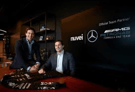 Zwei Männer vor einer Partnerwand von Nuvei und dem Mercedes-AMG Petronas Formel-1-Team, Zeichen von Nuveis globaler Präsenz.