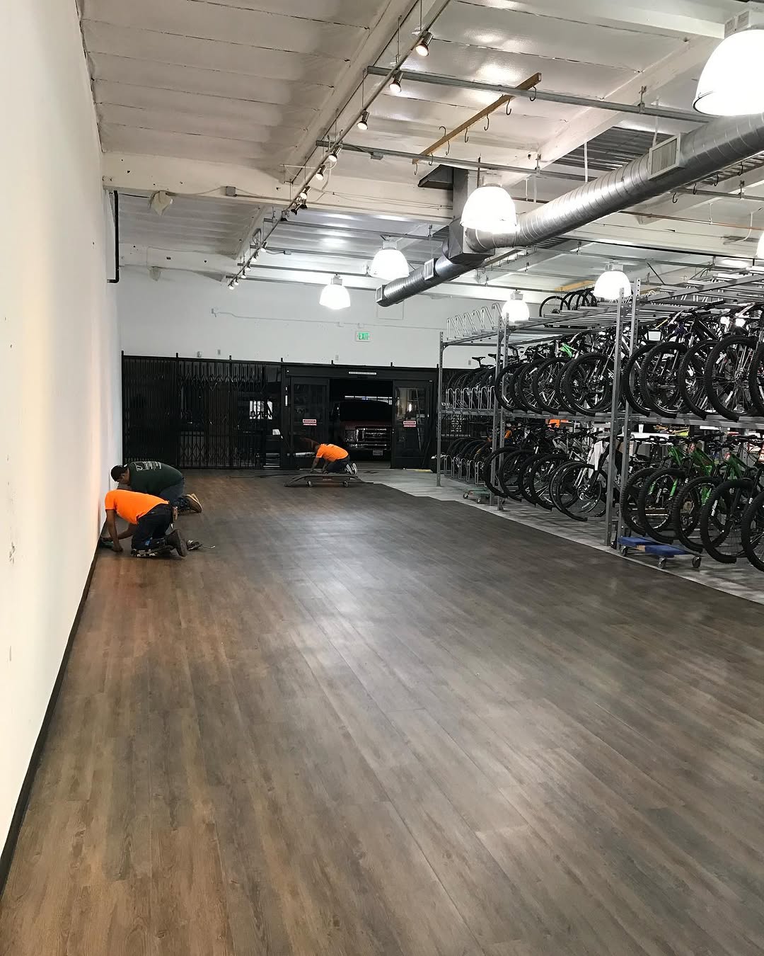 Dark wood-look LVT nearly complete through a retail space