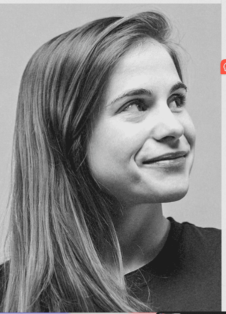 Portrait of a young man with short hair, wearing a dark t-shirt, against a plain background.
