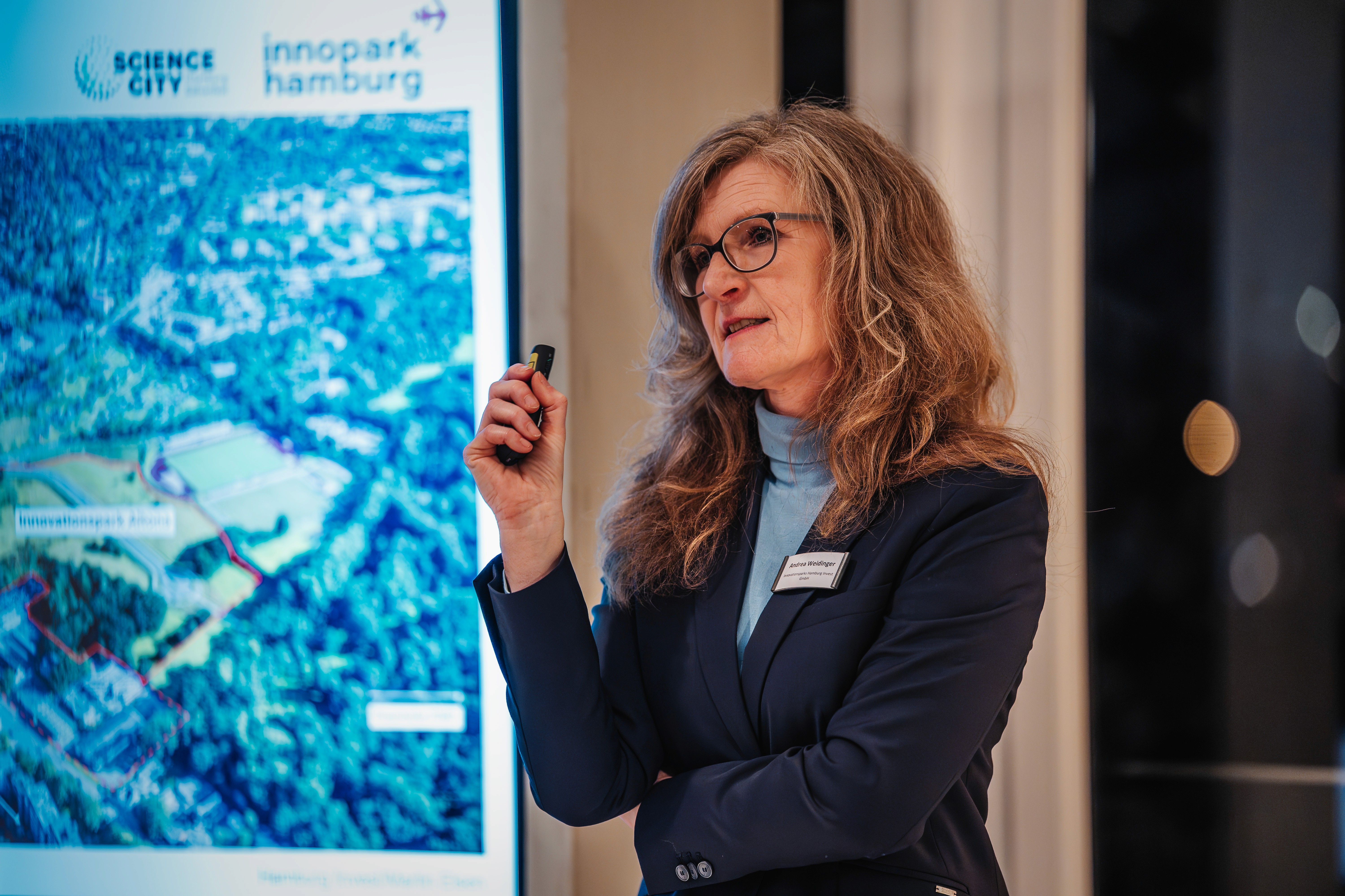 People crossing a busy street with cars and buildings.