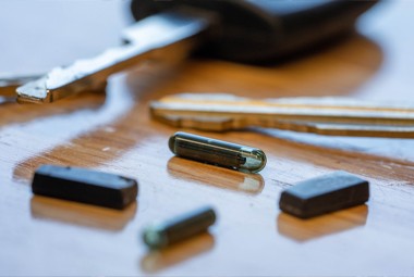 Close-up of transponder car key chips and key components used for chip key programming.