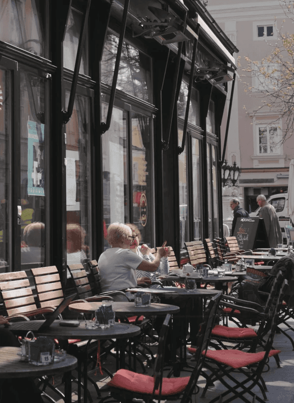 Kunden sitzen vor dem Cafe