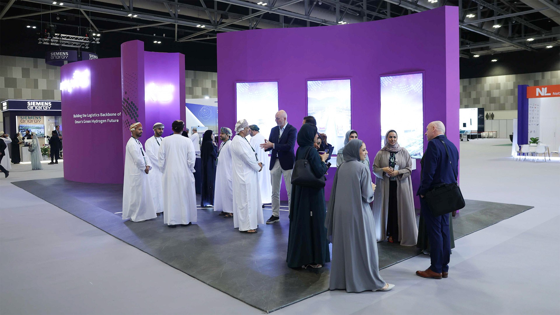 A rocky river flows through a sunlit forest valley.