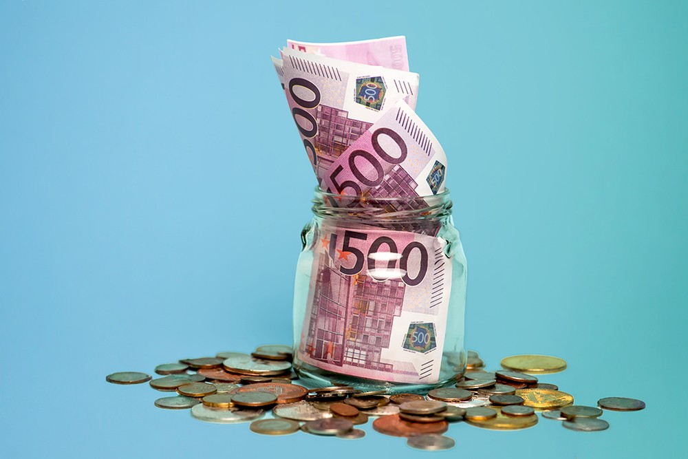 Glass filled with banknotes and coins