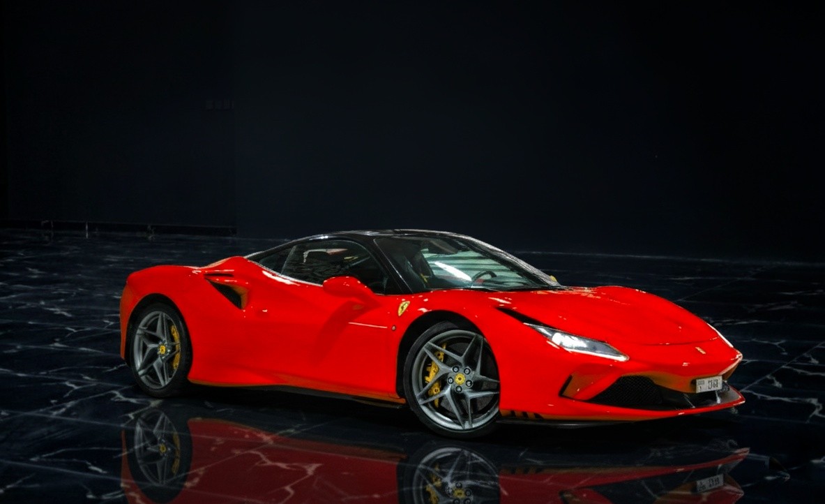 Red Ferrari F8 Tributo coupe for rent in Dubai by Queen of Supercar Rental, featuring a twin-turbo V8 and luxury supercar design.