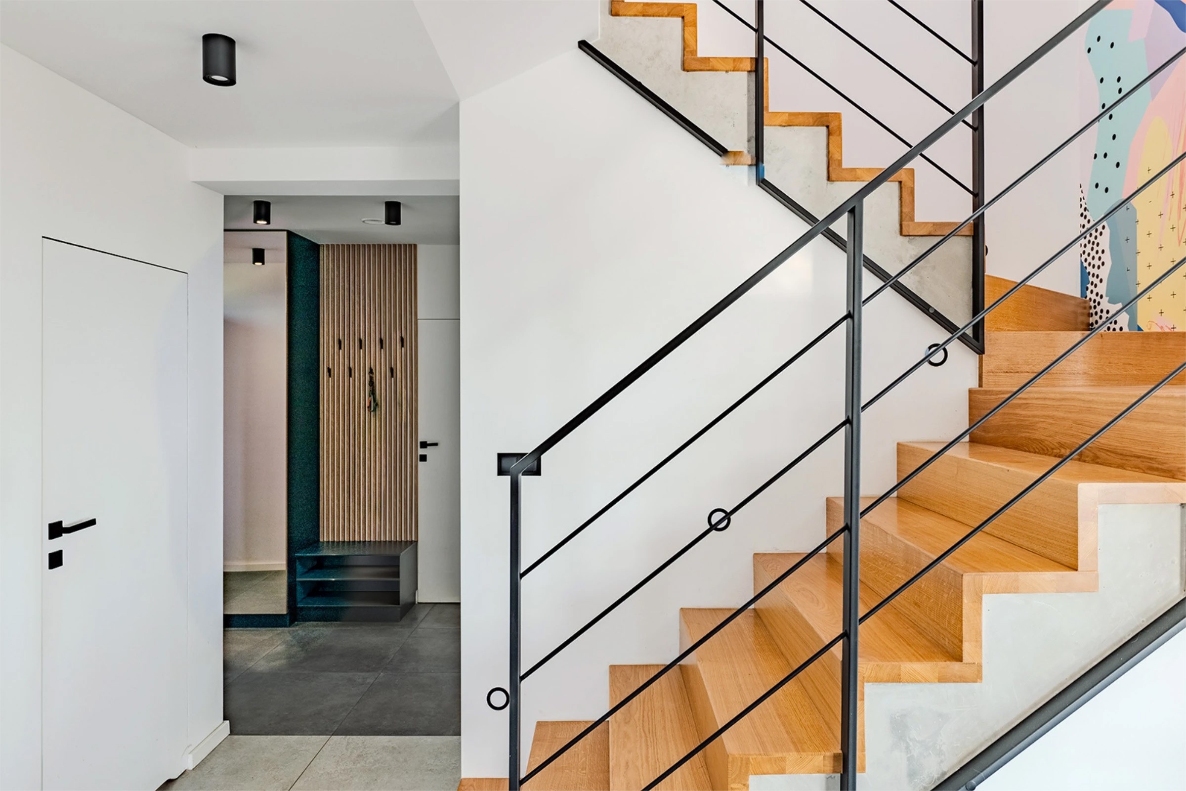 Wnętrze jasnego domu, klatka schodowa i przedpokój, pomalowane na biało