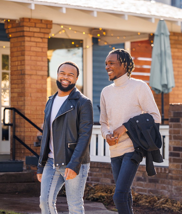 Men walking down street smiling