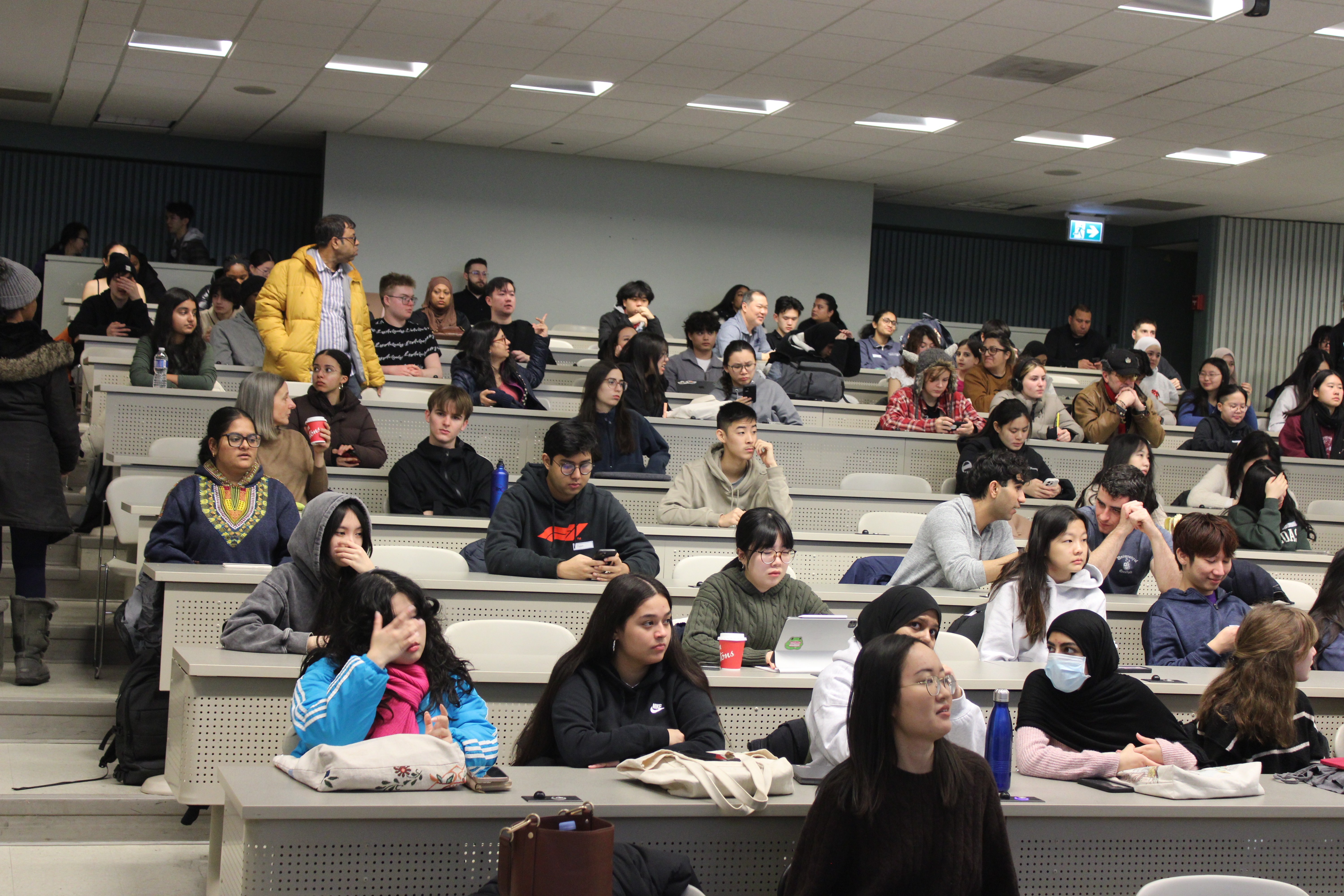 A fast black sports car races down the highway.