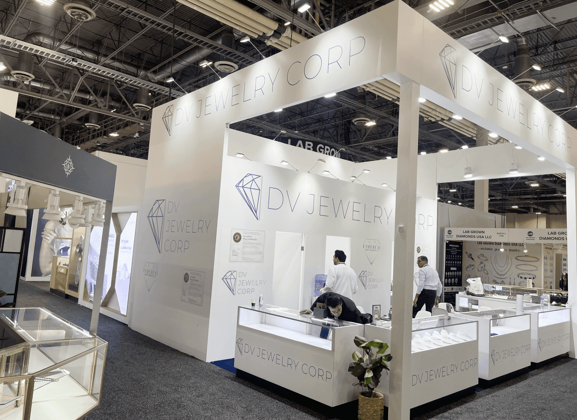 20x20 JCK booth planning at Venetian Expo with jewelry display counters, buyer consultation area, lighting, and branded graphics