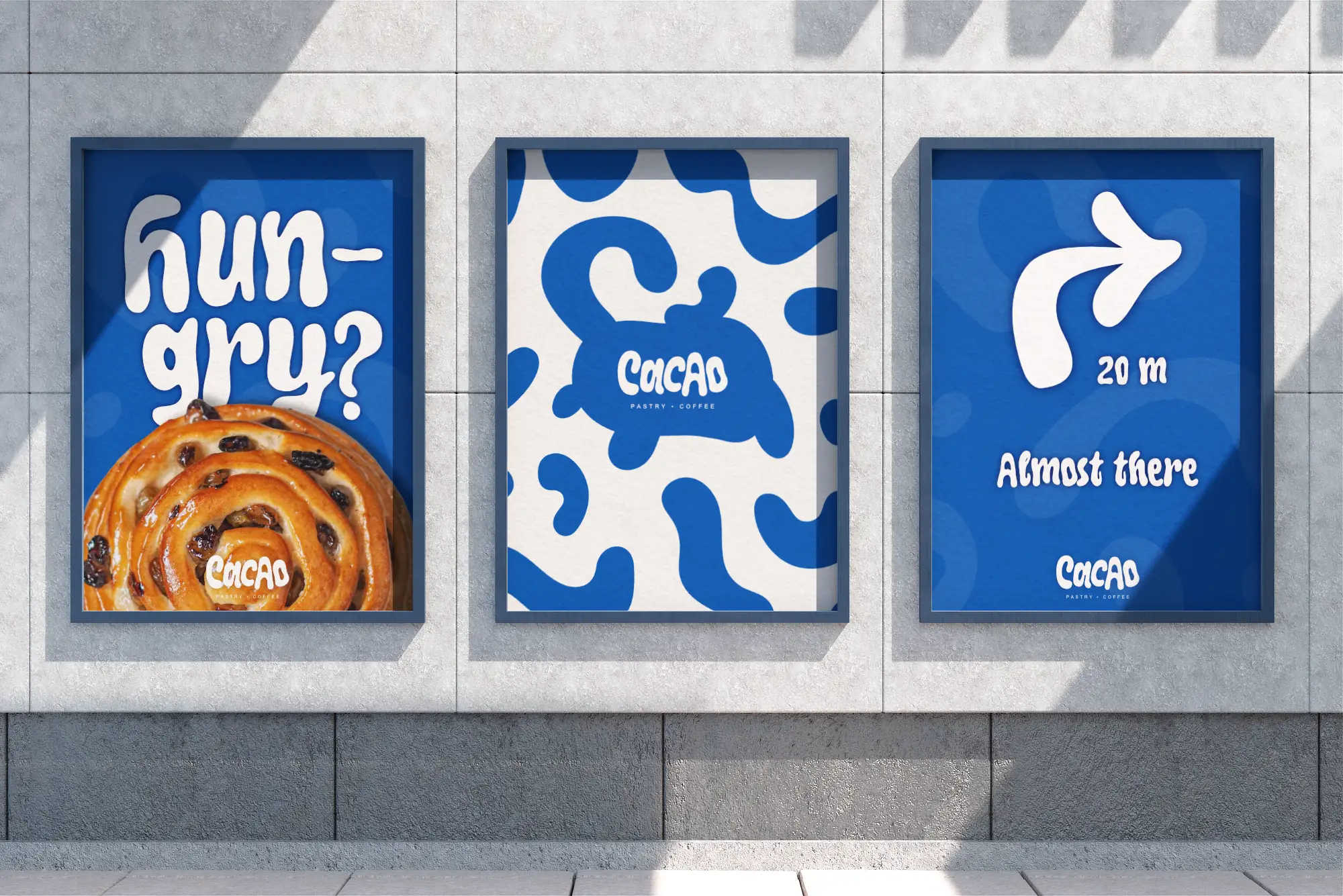Three directional promo posters for Cacao designed by Studio Liminal, featuring a cinnamon roll with the text "HUNGRY?", a brand logo and pattern layout, and an arrow pointing 20 meters to the shop.