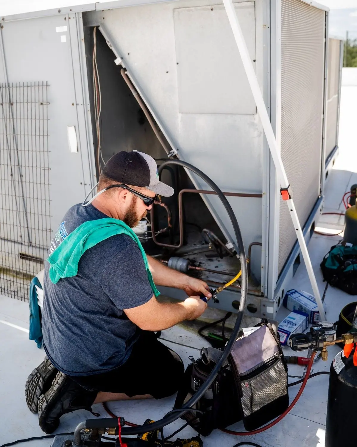 Technicien de Beauregard Climatisation effectuant une réparation sur un système de climatisation commercial sur un toit