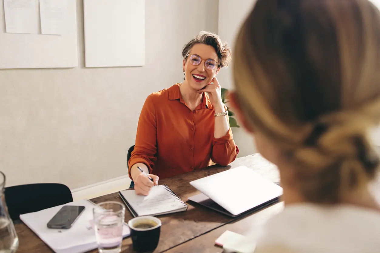 Two women having a positive and engaged one-on-one meeting representing supportive leadership and wellbeing