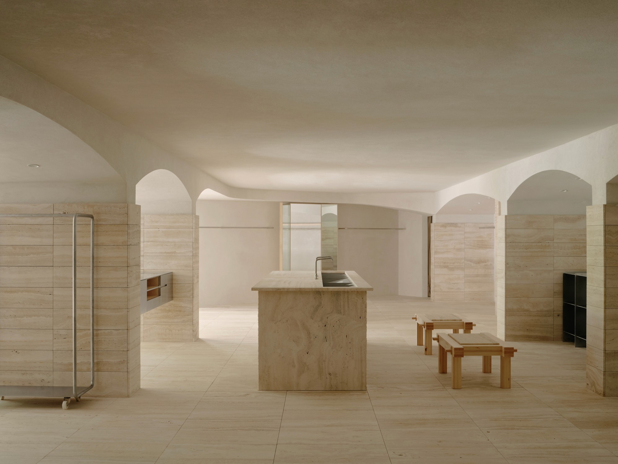 Minimalist passageway with tall curved rust-colored metal walls and dramatic sunlight shadows.