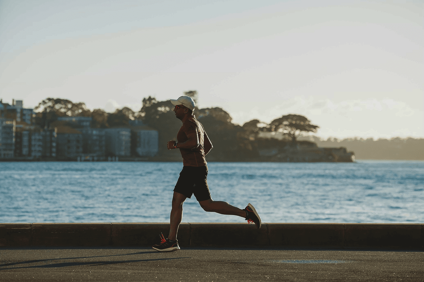 Man running along a waterfront during daylight