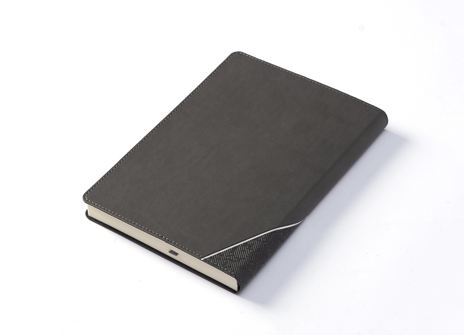 Back angled view of closed grey notebook with textured spine accent.